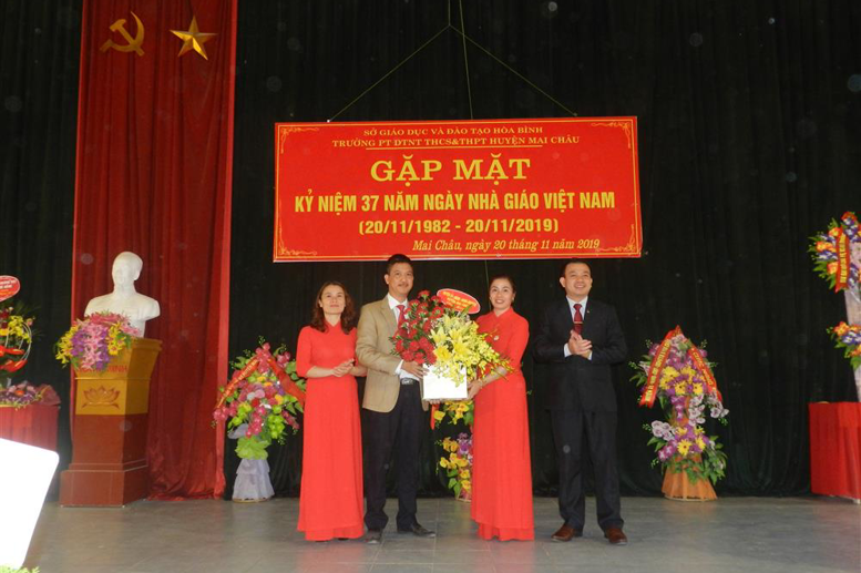Ông Hà Văn Di - Phó Bí thư TT, Chủ tịch HĐND huyện tặng hoa chúc mừng tập thể nhà trường