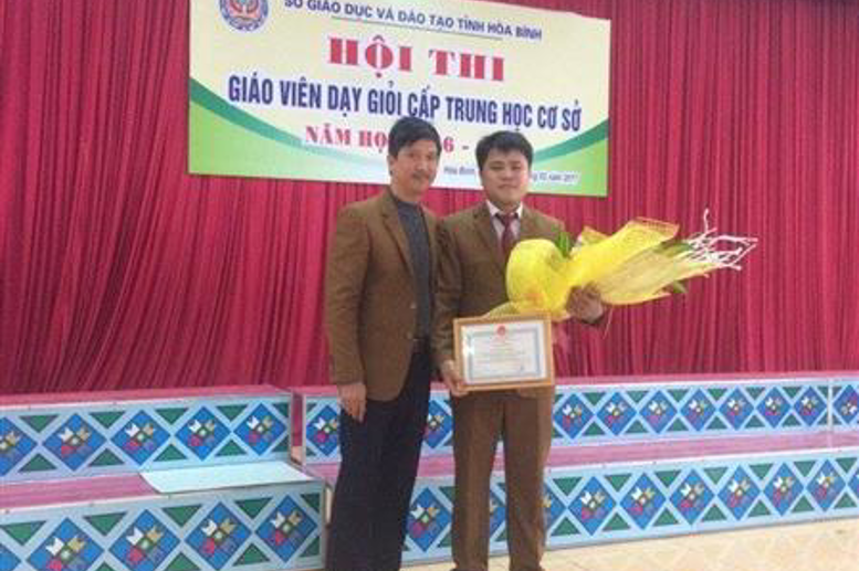 Thầy giáo Tạ Quang Sỹ-PHT, trưởng đoàn tham gia hội thi,  tặng hoa chúc mừng thầy giáo Ngần Văn Toàn tại lễ tổng kết hội thi